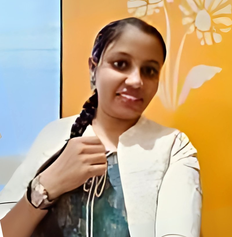 Amruta Kashid, Graphics Designer, smiling in front of a yellow wall
