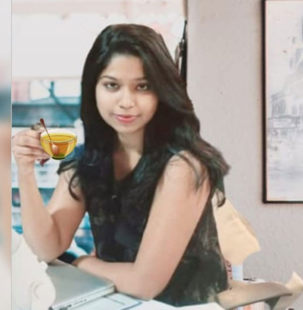 Deeksha Ijagaj, Manager, holding a cup of tea at her desk